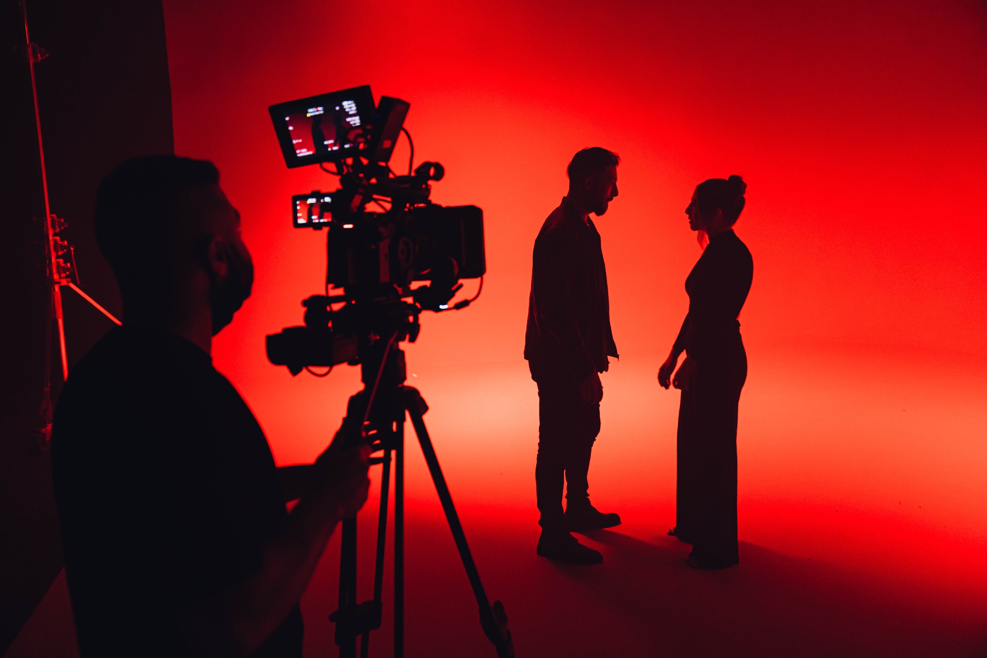 Silhouetted crew and talent on a red-lit film set